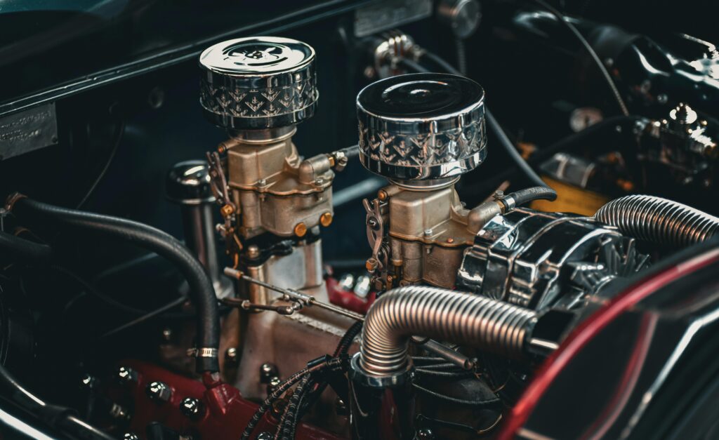 pexels photo 32674055 32674055 Close-up of a classic car engine showcasing intricate details of twin carburetors and metallic components.